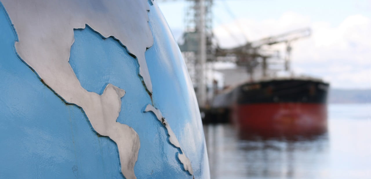 Globe sits in the foreground with red shipping container in the background