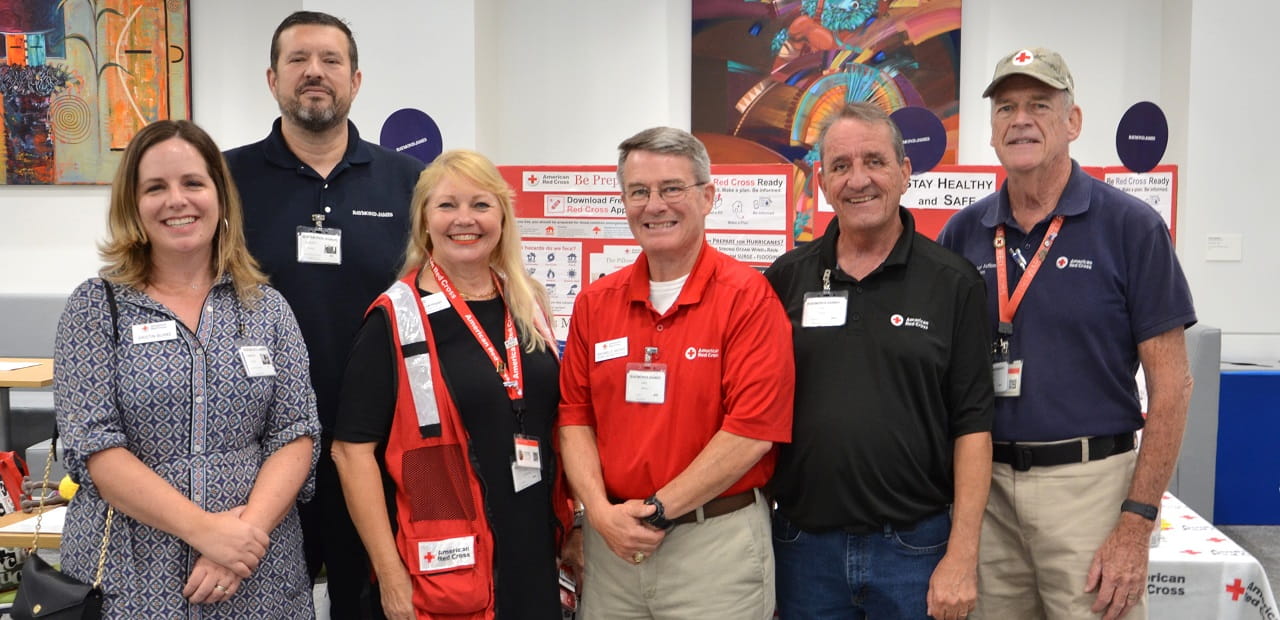 Red Cross staff members and Raymond James board member pose at Raymond James home office